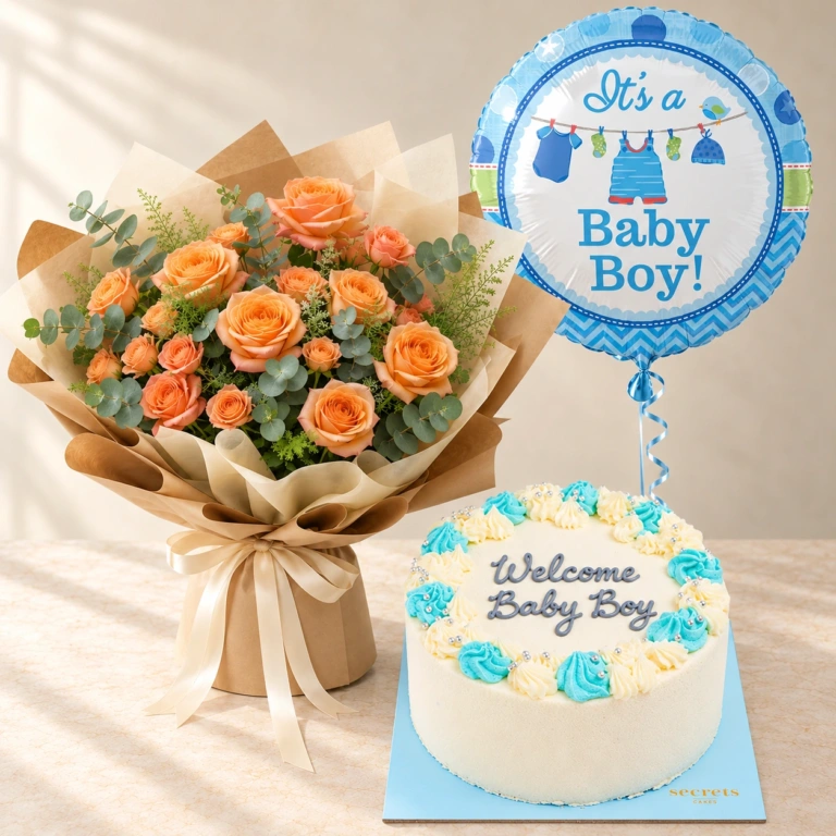 Apricot-orange roses with one blue Baby Boy balloon and a blue cake reading Welcome Baby Boy